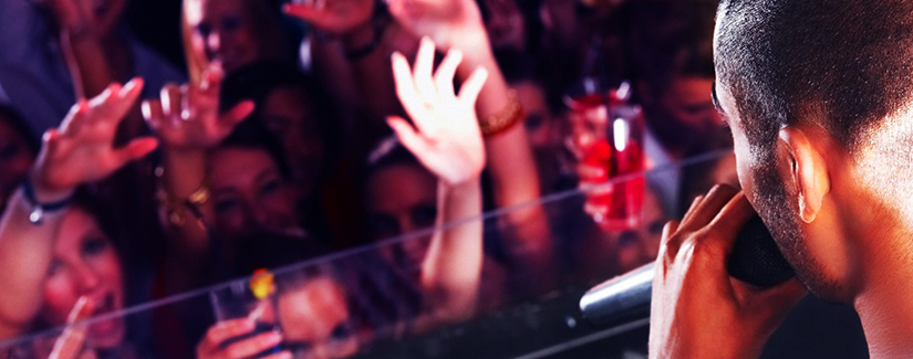显示DJ的图像站在一个DJ展位在夜总会，在一群年轻的派对队